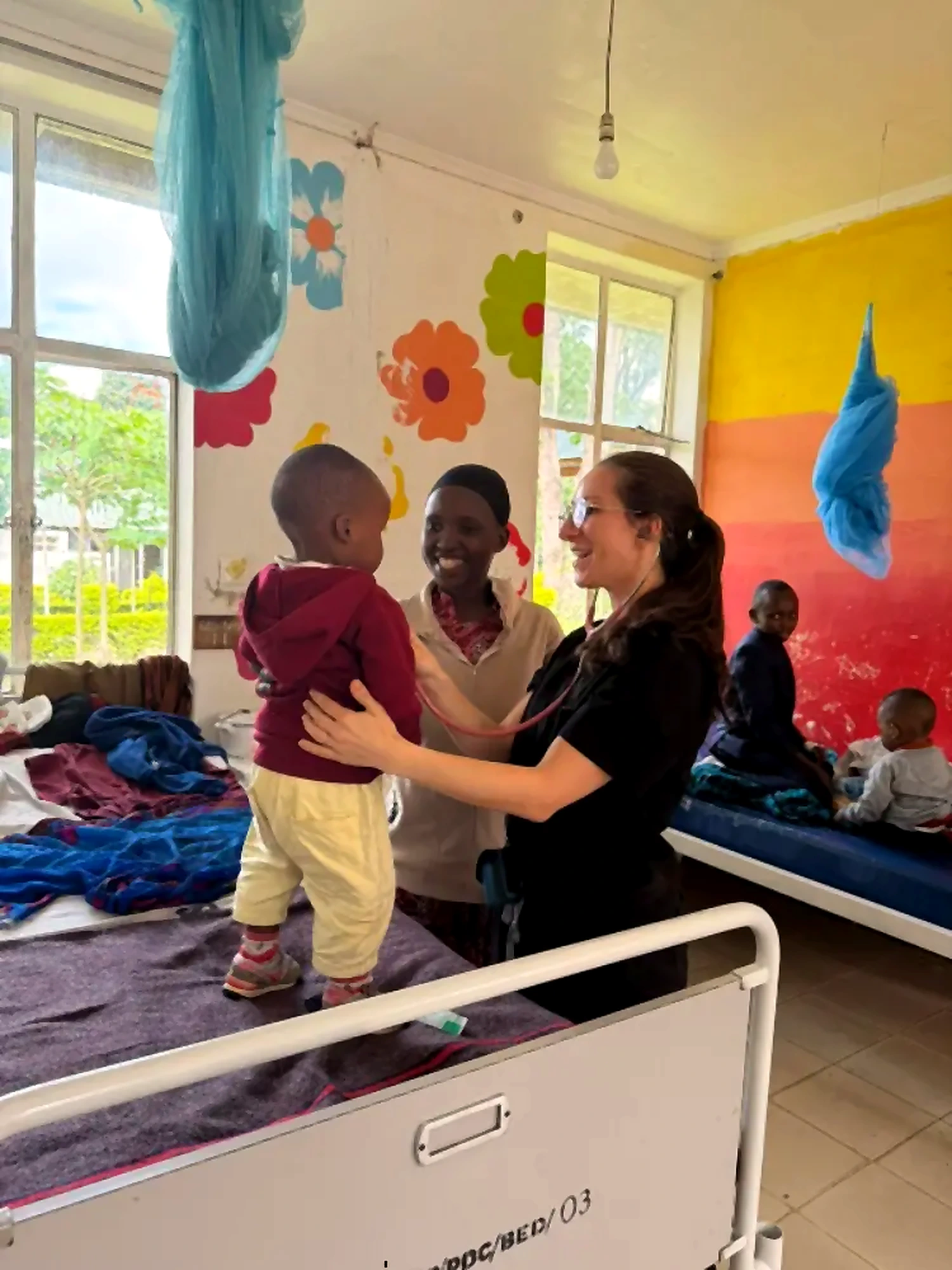 Healthcare volunteer supporting a child in a ward setting